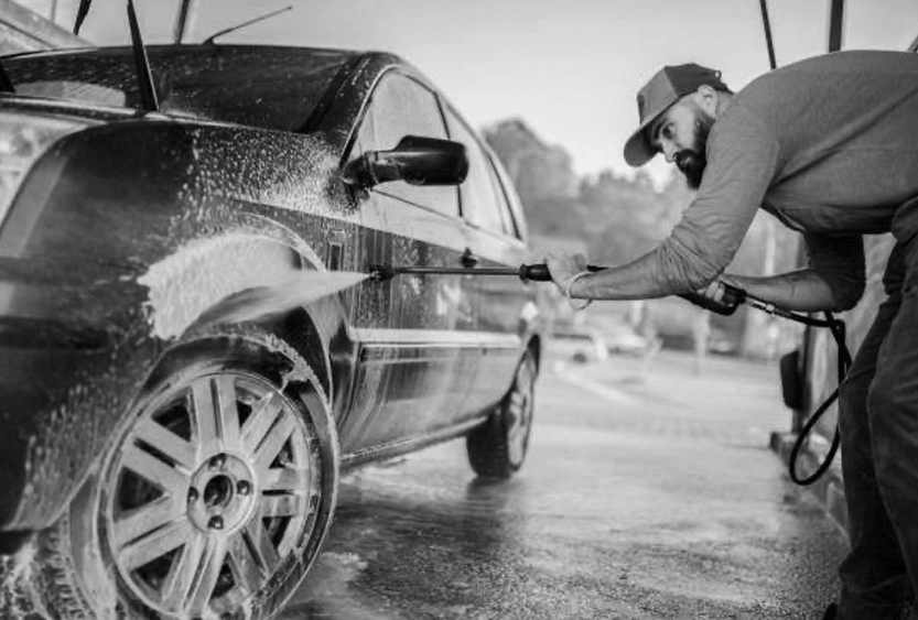 A man wash his car with high pressure cleaner